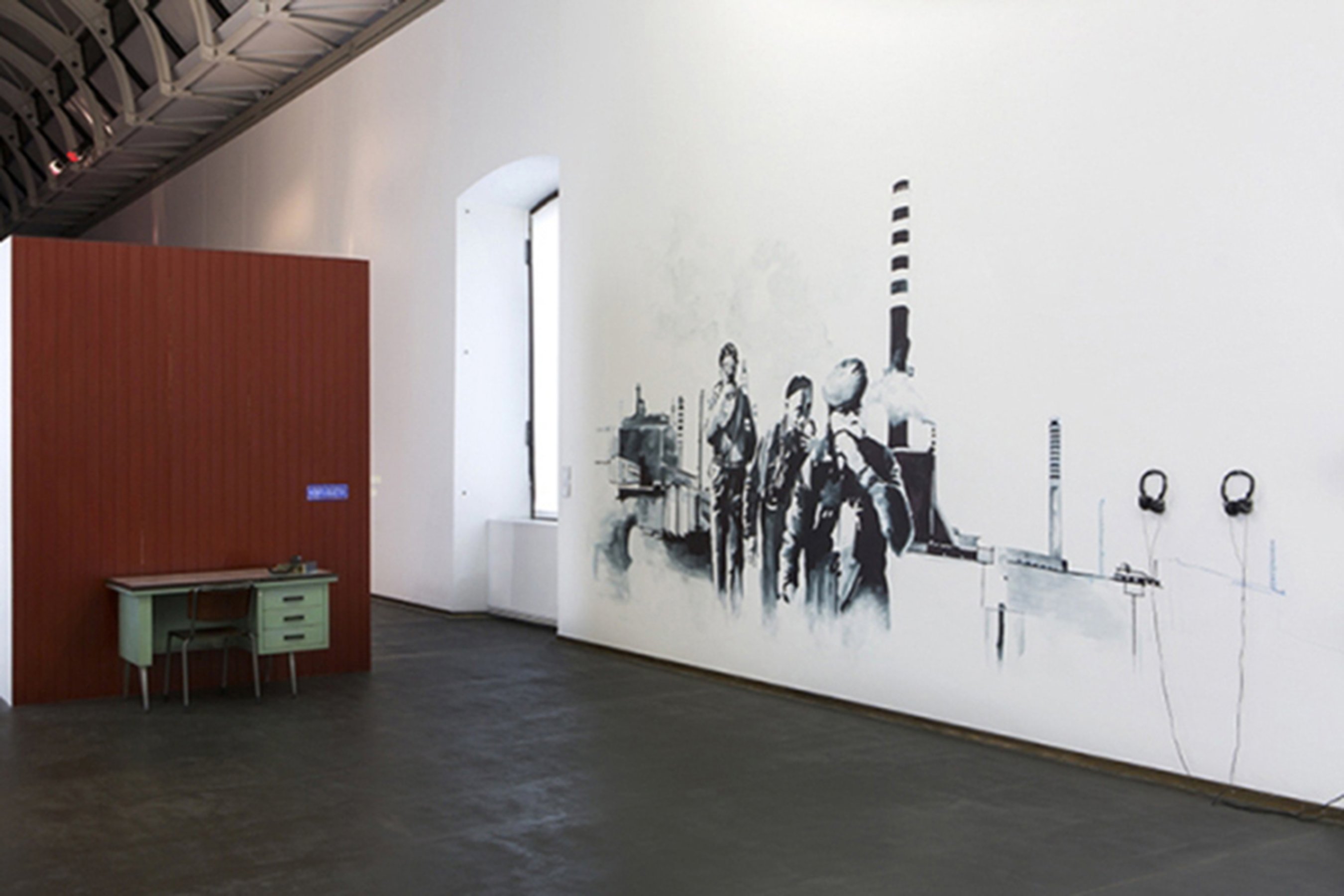 Estman Radio Drama, 2011 Installation: painted wood wall, desk, chair, radio, 4 CD players, 4 headphones Dimensions determinated by the space Installation view at Castello di Rivoli, Italy Photo Renato Ghiazza