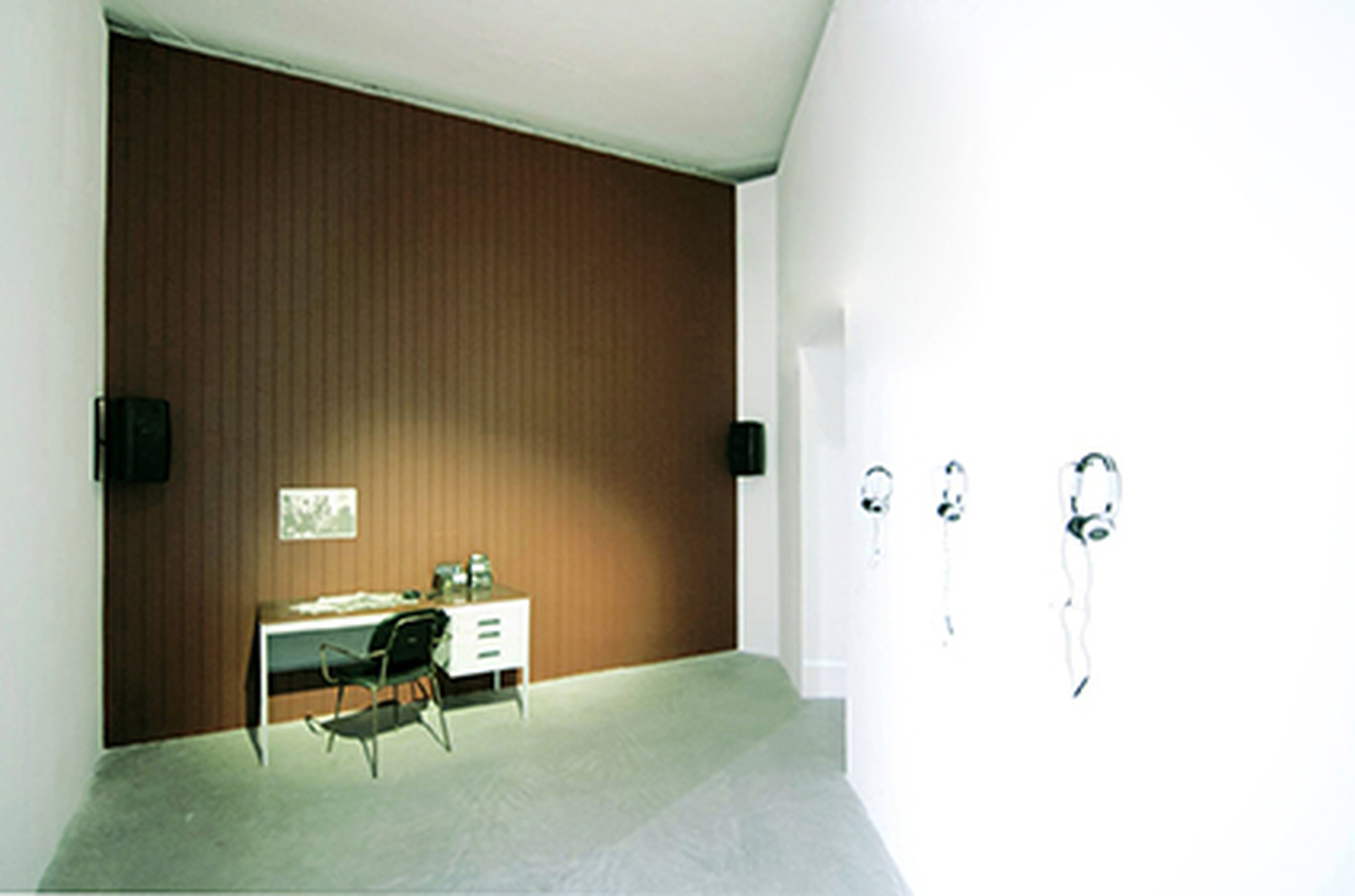 Estman Radio Drama, 2011 Installation: painted wood wall, desk, chair, radio, 4 CD players, 4 headphones Dimensions determinated by the space Installation view at 54th Biennial of Venice, ILLUMINATIONS, Venice (IT)