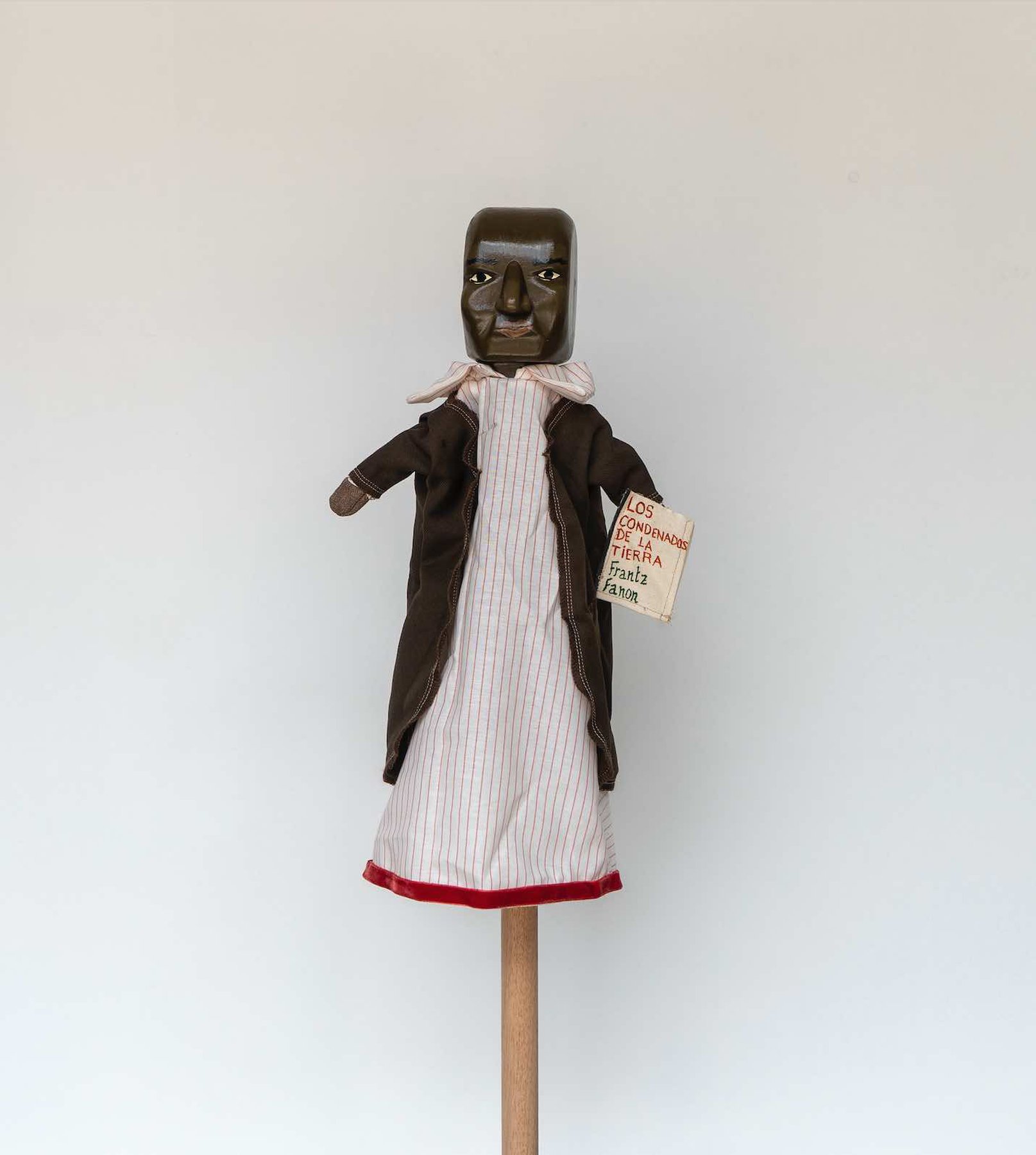 Daniela Ortiz, The Brightness of Greedy Europe, 2022, wood hand-carved, sewn, knitted and embroidered costumes (25 cm) puppet - Frantz Fanon
