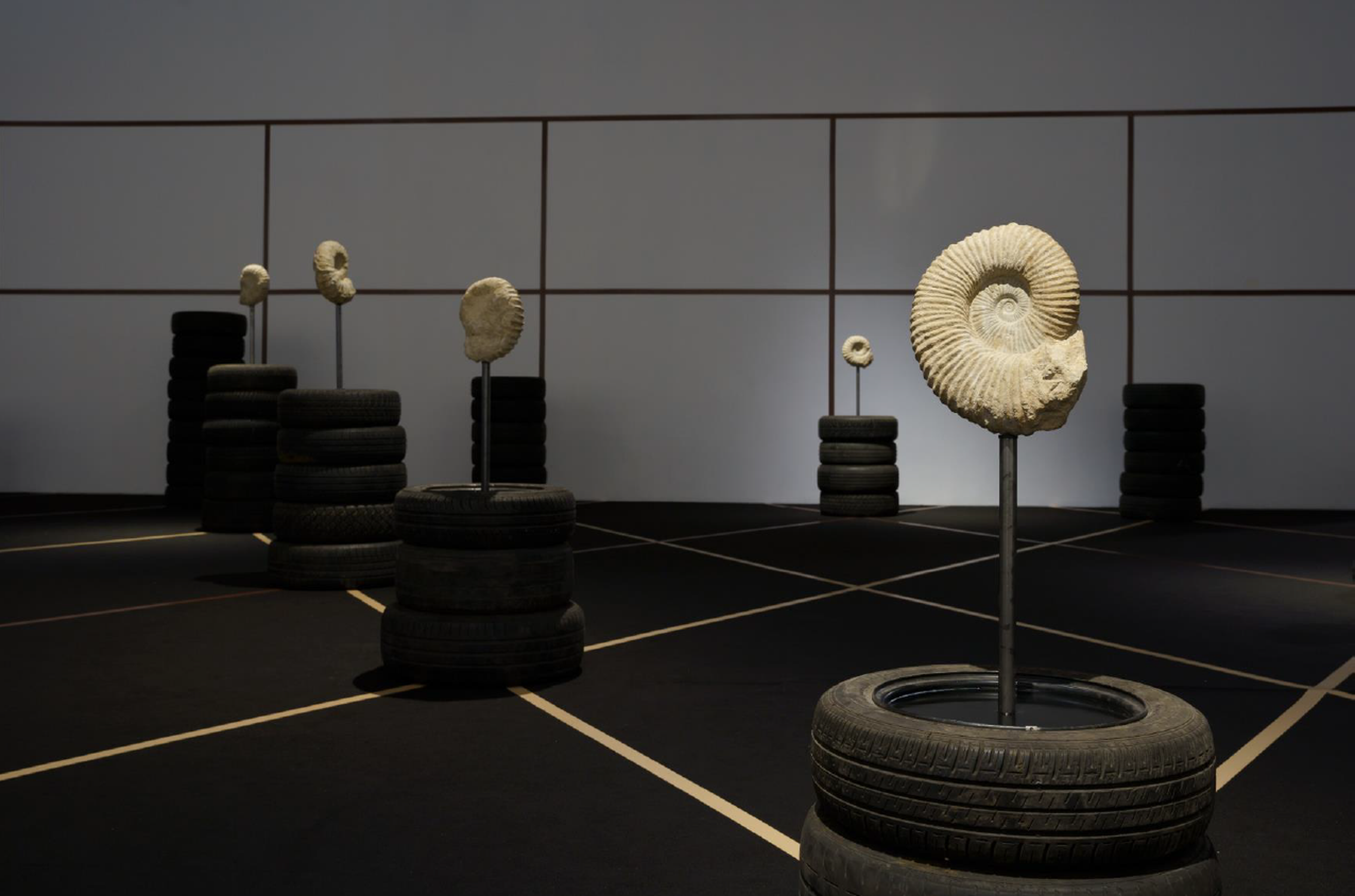 We Demand a Million More Years ( 2022 Jonas Staal Ammonite fossils of approximately 100 million years old, metal rods, hardened oil, defunct car tires, various dimensions